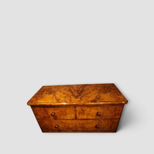 fig 2. A Victorian burr walnut chest of drawers featuring two short drawers over three long drawers with turned walnut knobs and a plinth base.