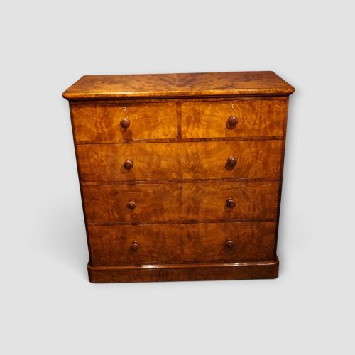 fig 3. A Victorian burr walnut chest of drawers featuring two short drawers over three long drawers with turned walnut knobs and a plinth base.