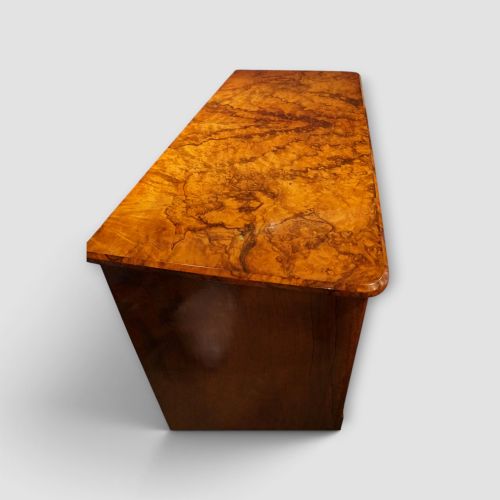 fig 9. A Victorian burr walnut chest of drawers featuring two short drawers over three long drawers with turned walnut knobs and a plinth base.