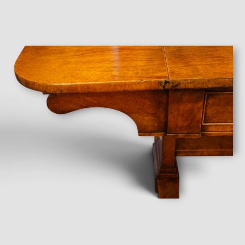 fig 9. A Regency burr satinwood sofa table with drop leaves, two frieze drawers, brass handles, and splayed legs on castors.