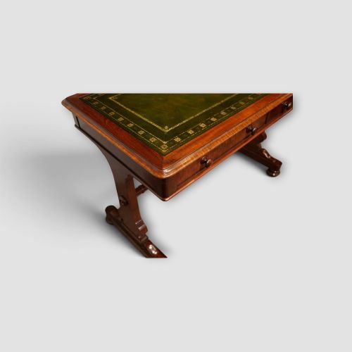 fig 9. An early Victorian mahogany writing table featuring a green leather inset top with gilt tooling, two frieze drawers, a turned stretcher, and end supports.