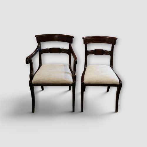 fig 1. A set of eight Regency mahogany dining chairs with neutral cream upholstery, carved back rails, and curved sabre legs.