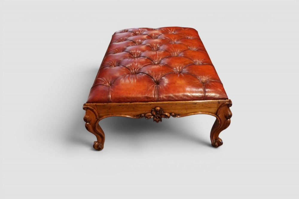 A large Victorian walnut stool featuring deep-buttoned russet red leather upholstery and carved cabriole legs. View IV