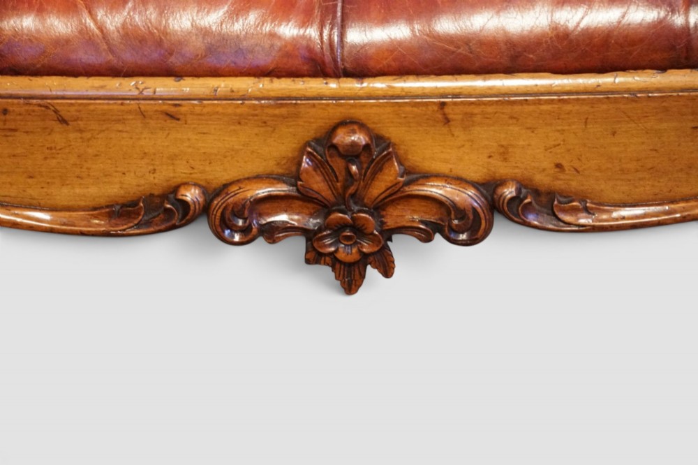 A large Victorian walnut stool featuring deep-buttoned russet red leather upholstery and carved cabriole legs. View V