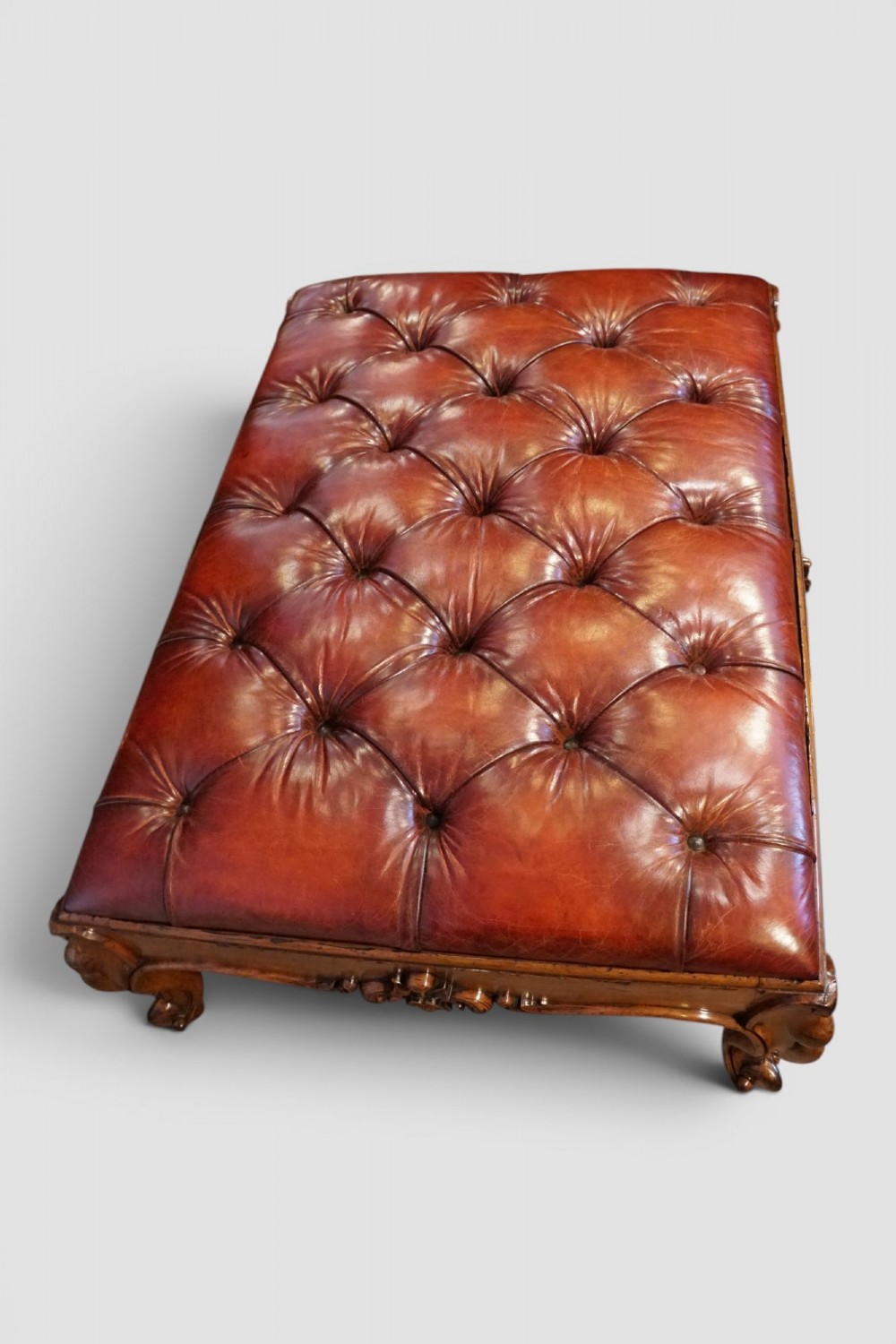 A large Victorian walnut stool featuring deep-buttoned russet red leather upholstery and carved cabriole legs. View VIII