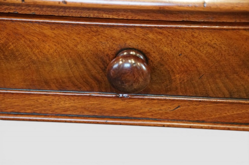 A Victorian mahogany partners writing table with a red leather gold-tooled insert top, frieze drawers, turned reeded legs, and brass castors. View V