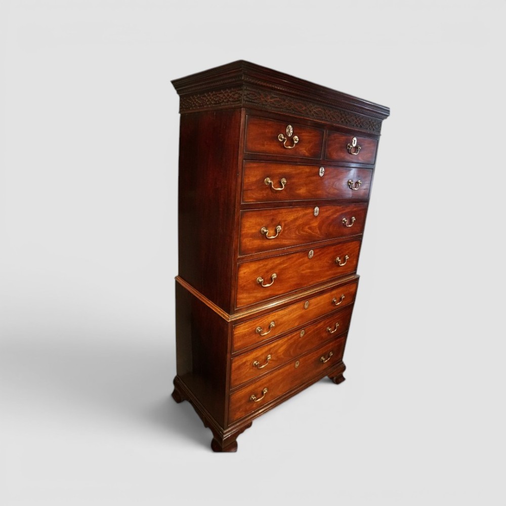 A tall George III mahogany chest-on-chest featuring a carved blind fretwork cornice, brass swan-neck handles, and bracket feet. View II