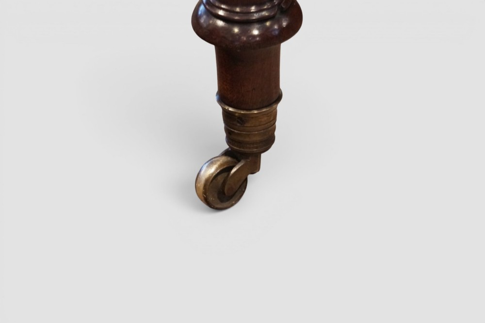 A Victorian mahogany partners writing table with a red leather gold-tooled insert top, frieze drawers, turned reeded legs, and brass castors. View XI