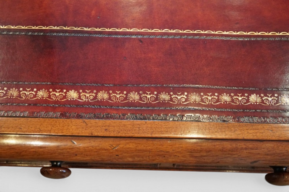 A Victorian mahogany partners writing table with a red leather gold-tooled insert top, frieze drawers, turned reeded legs, and brass castors. View XII