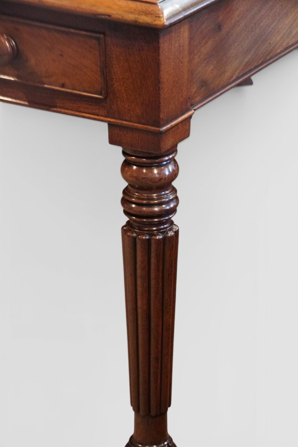A Victorian mahogany partners writing table with a red leather gold-tooled insert top, frieze drawers, turned reeded legs, and brass castors. View XIII