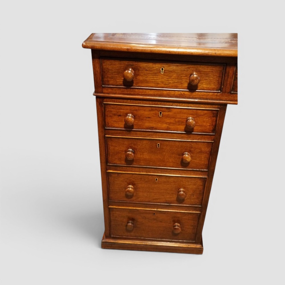 A Victorian mahogany partners desk featuring a tooled leather writing surface, twin pedestals, and an eleven-drawer front configuration with turned wooden knobs. View III