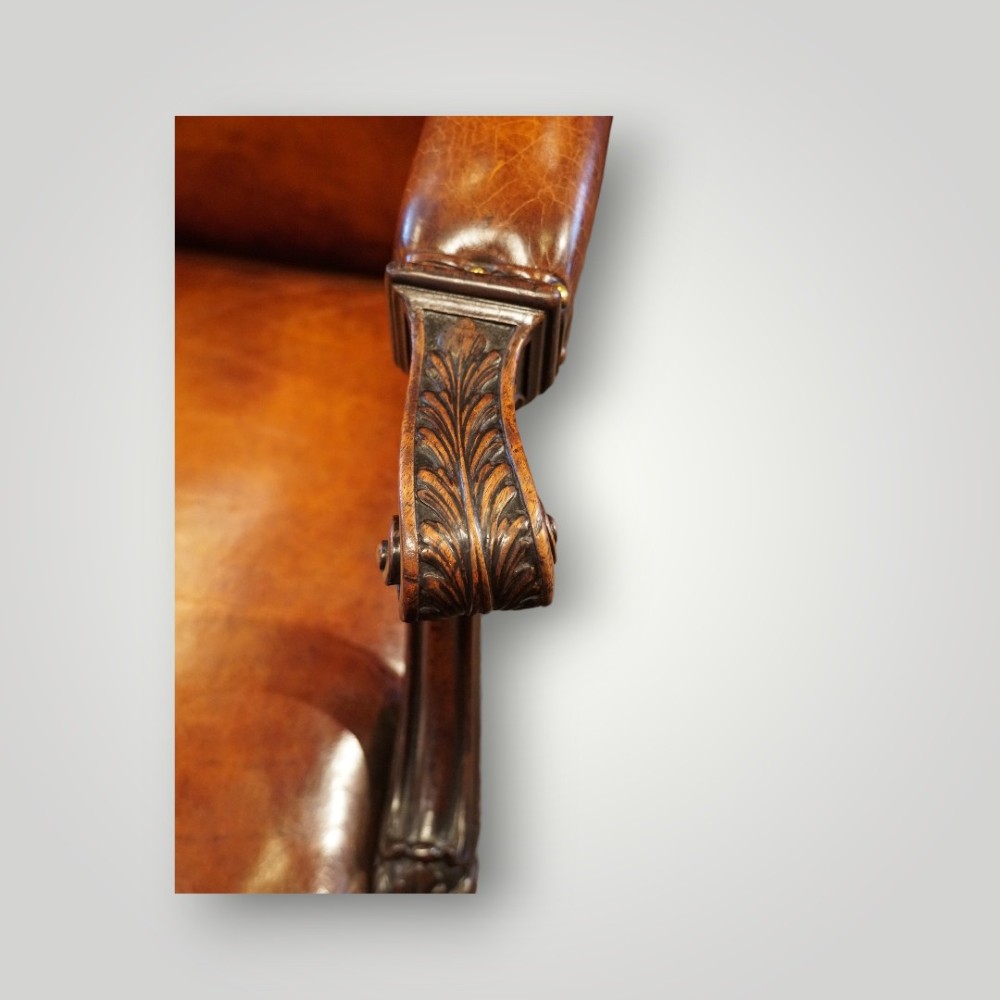 A Georgian style Gainsborough armchair upholstered in warm tan leather with brass stud detailing and carved mahogany legs. View III
