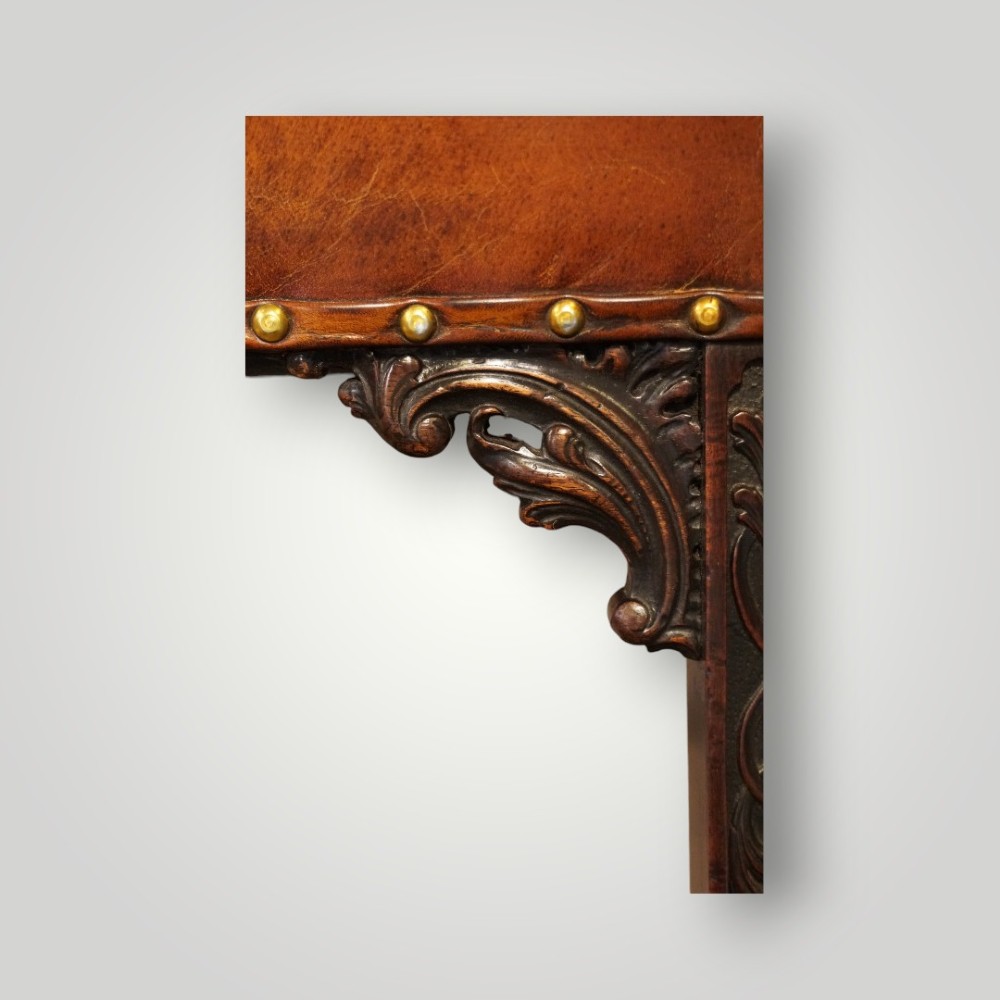 A Georgian style Gainsborough armchair upholstered in warm tan leather with brass stud detailing and carved mahogany legs. View VII