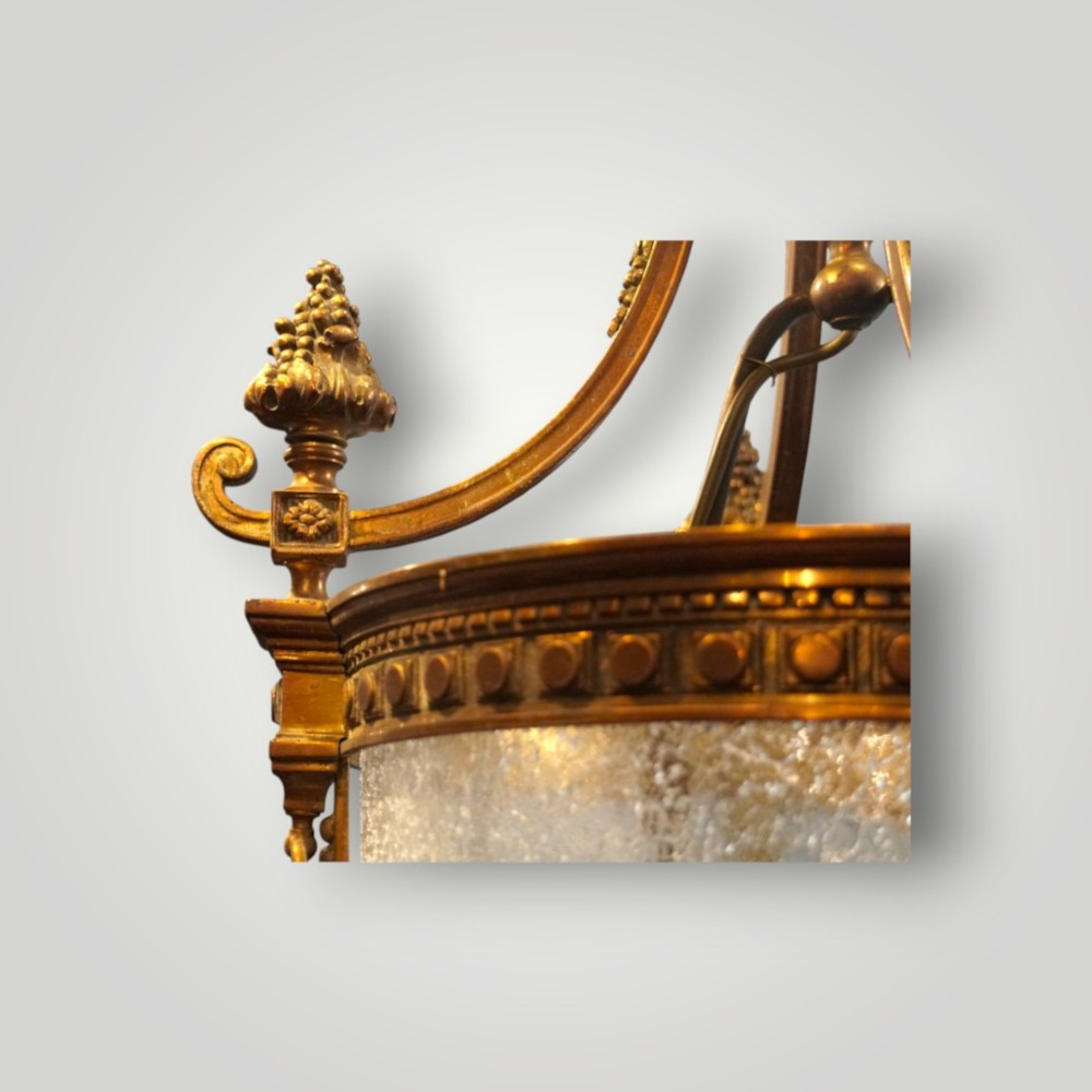 A nineteenth-century gilt bronze hall lantern featuring a tapered glass vessel, acanthus leaf canopy, and decorative drapery swags. View II