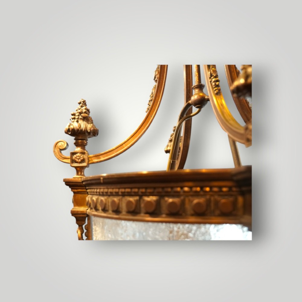 A nineteenth-century gilt bronze hall lantern featuring a tapered glass vessel, acanthus leaf canopy, and decorative drapery swags. View VIII