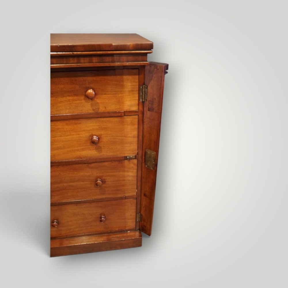 A Victorian warm brown mahogany Wellington chest featuring four stacked drawers with turned wooden handles and a side locking bar. View VI