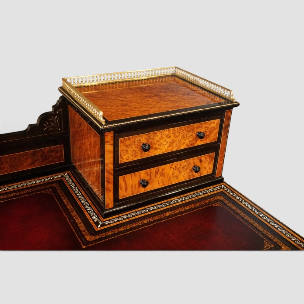 A Victorian ebonised and thuya wood pedestal desk featuring a leather writing surface, raised side drawers, ivory inlay, and ceramic plaque details. View VI