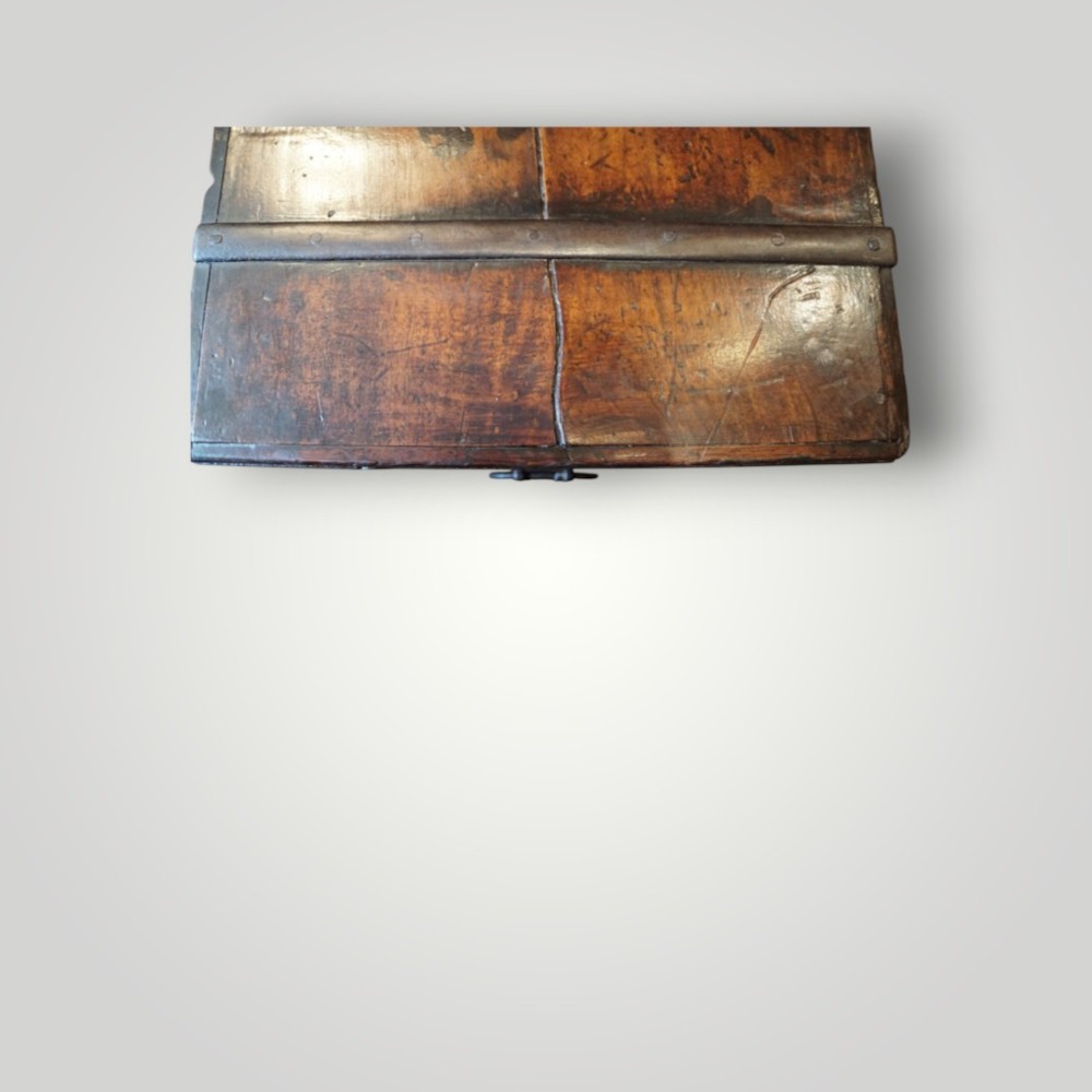 A rectangular antique walnut wood trunk featuring heavy iron binding straps, metal corner hardware, and a brass plaque on the lid. View X