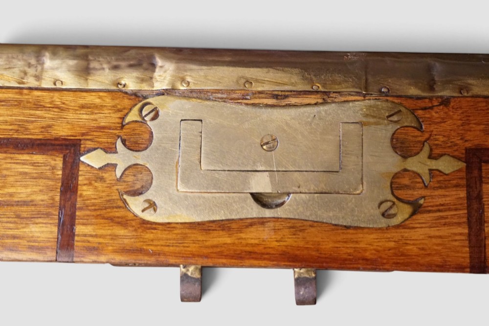 A rectangular Victorian camphor wood campaign chest featuring polished brass binding along the edges, geometric dark line inlay, and a central brass lock escutcheon. View VI