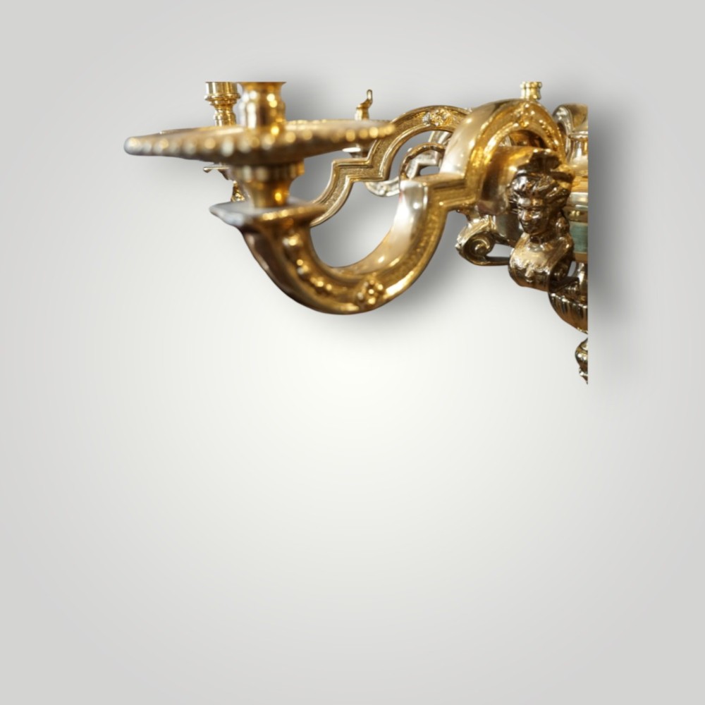 A nineteenth-century French gilt bronze eight-light chandelier featuring a central urn column and scrolling candle arms with faux candle sleeves. View II