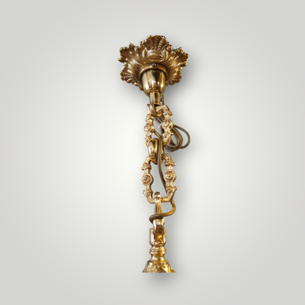 A nineteenth-century French gilt bronze eight-light chandelier featuring a central urn column and scrolling candle arms with faux candle sleeves. View IV
