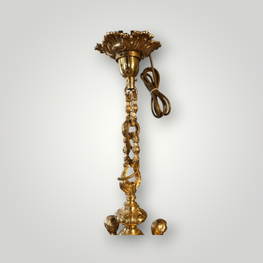 A nineteenth-century French gilt bronze eight-light chandelier featuring a central urn column and scrolling candle arms with faux candle sleeves. View V