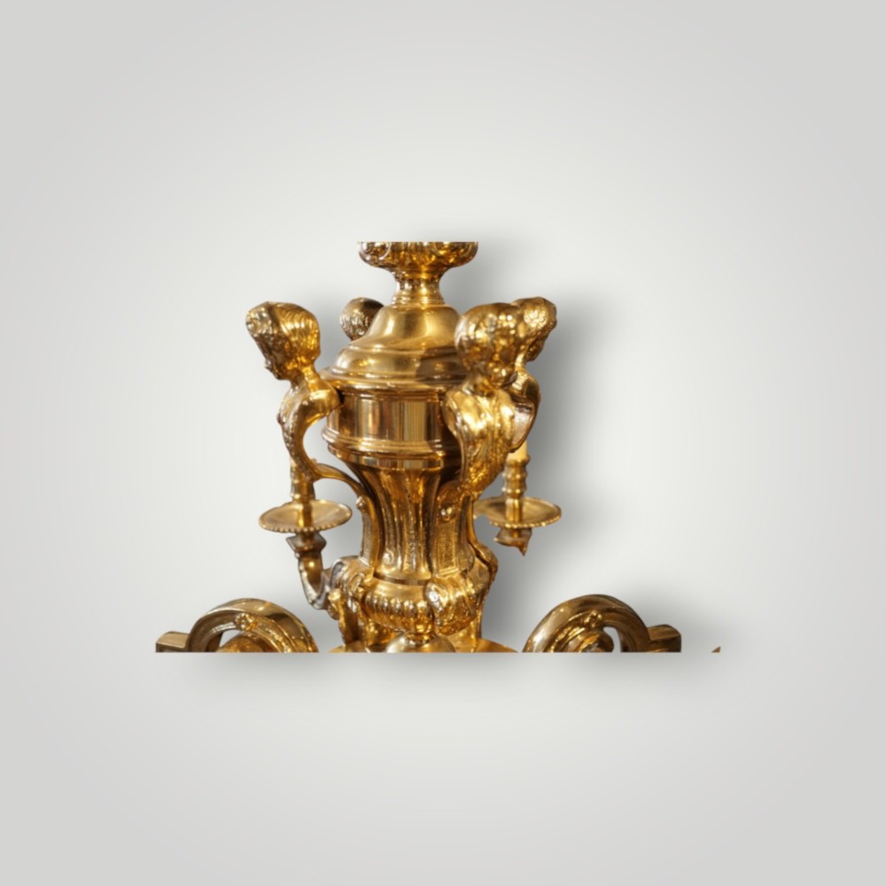 A nineteenth-century French gilt bronze eight-light chandelier featuring a central urn column and scrolling candle arms with faux candle sleeves. View VII