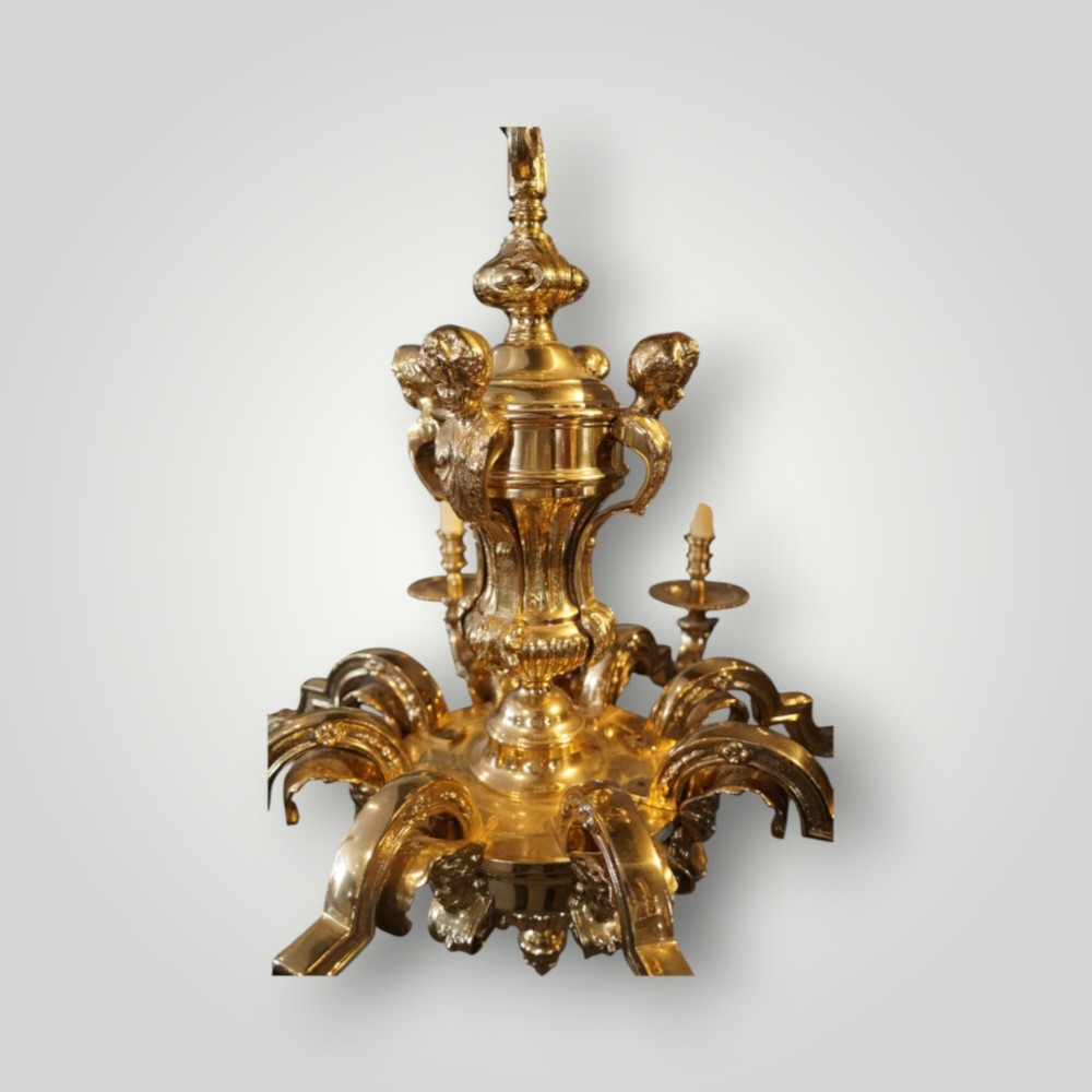A nineteenth-century French gilt bronze eight-light chandelier featuring a central urn column and scrolling candle arms with faux candle sleeves. View X