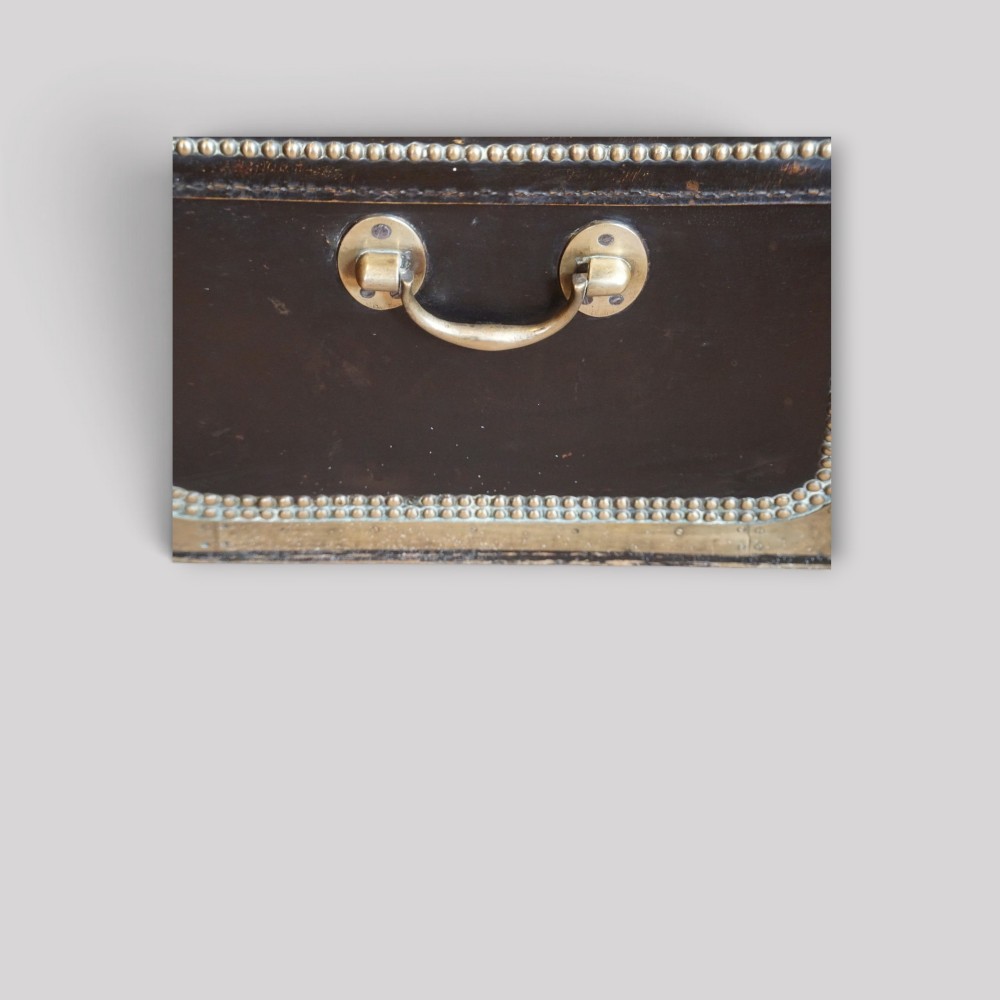 An antique dark green leather trunk featuring brass corner straps, close-studded brass borders, and a brass keyhole escutcheon. View IX
