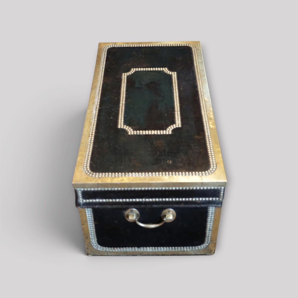 An antique dark green leather trunk featuring brass corner straps, close-studded brass borders, and a brass keyhole escutcheon. View X