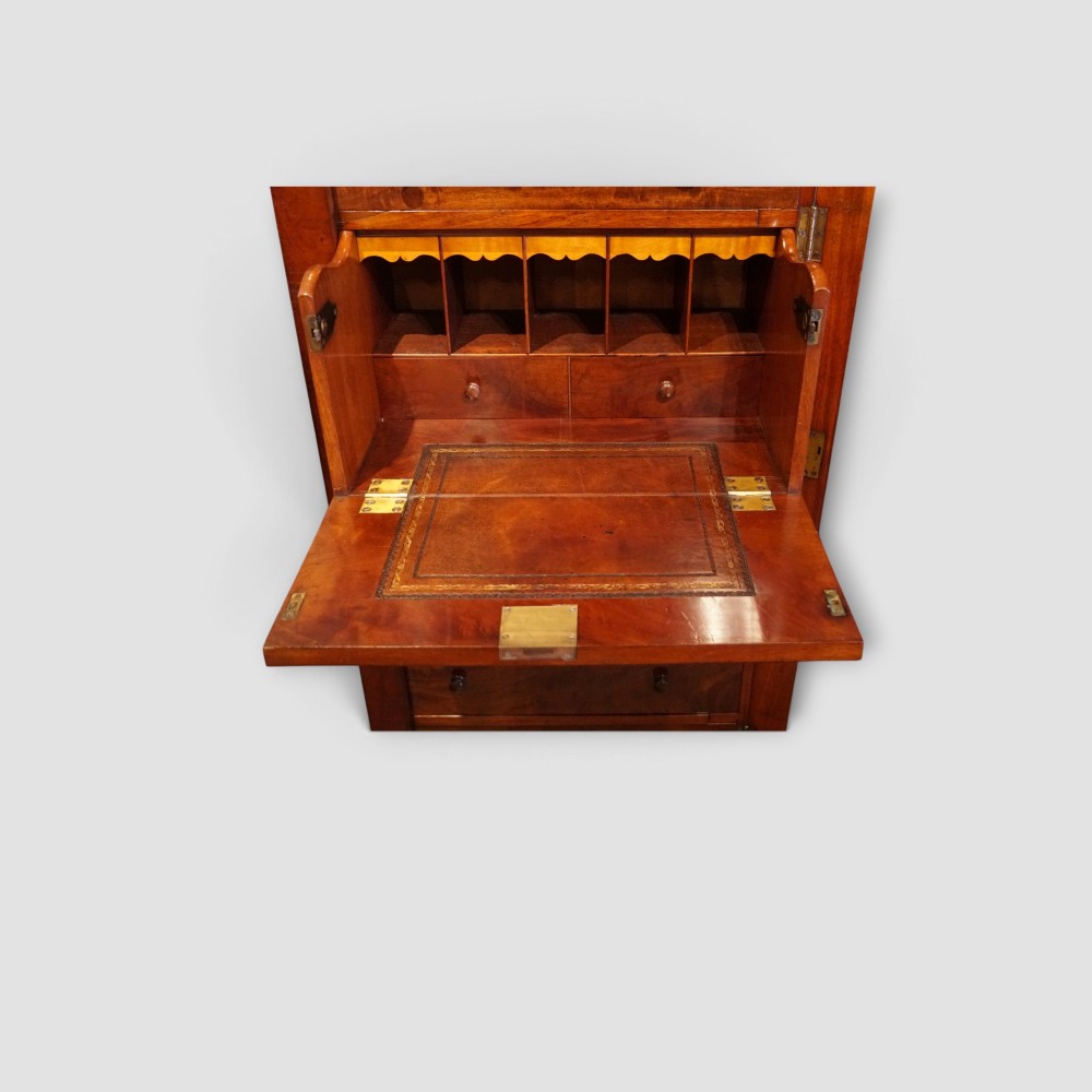 A tall Victorian mahogany Wellington chest featuring seven drawer fronts, turned wooden knobs, and a right-hand side locking flap. View VI