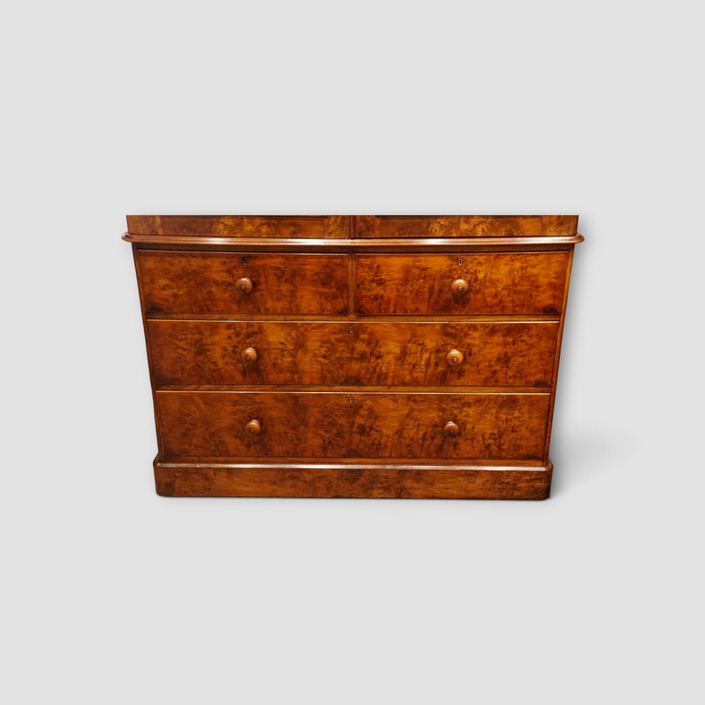 A 19th-century Victorian burr walnut linen press featuring an upper cabinet with arched panel doors over a chest of four drawers with turned wooden knobs. View II