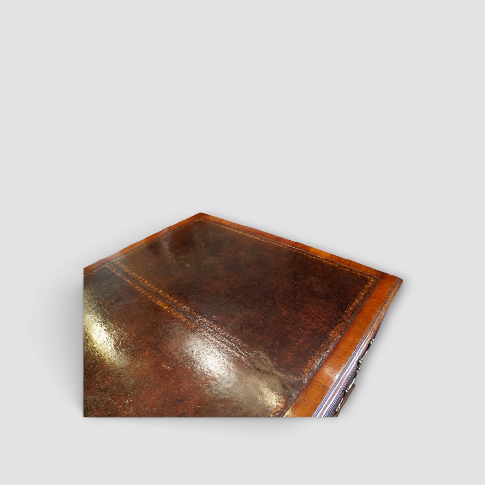 A large Victorian mahogany partners desk featuring a brown leather inset writing surface, twin drawer pedestals, brass swan-neck handles, and a wide central kneehole. View VI