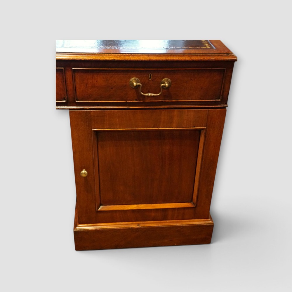 A large Victorian mahogany partners desk featuring a brown leather inset writing surface, twin drawer pedestals, brass swan-neck handles, and a wide central kneehole. View IX