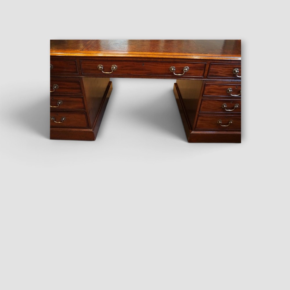 A large Victorian mahogany partners desk featuring a brown leather inset writing surface, twin drawer pedestals, brass swan-neck handles, and a wide central kneehole. View XI