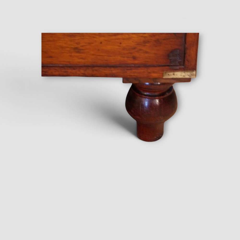A Victorian teak two-part military campaign chest of drawers featuring flush brass handles, brass corner mounts, and turned feet. View VII