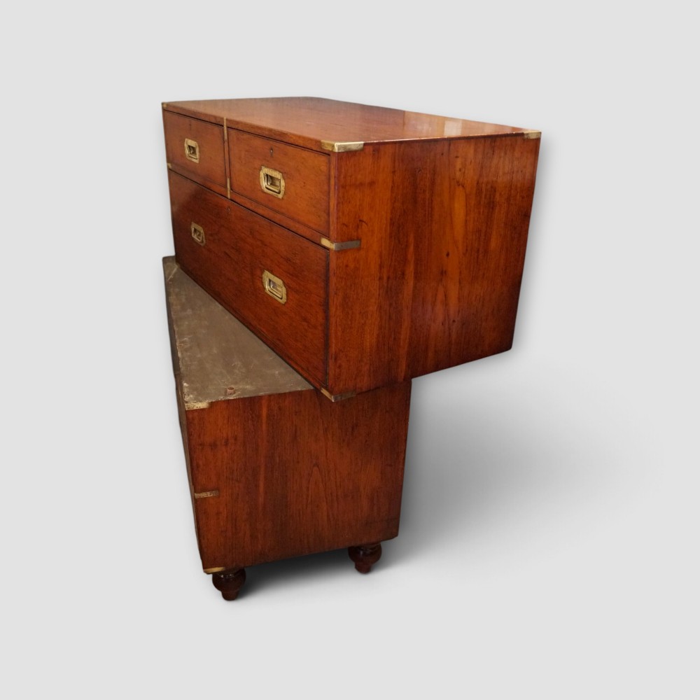 A Victorian teak two-part military campaign chest of drawers featuring flush brass handles, brass corner mounts, and turned feet. View VIII