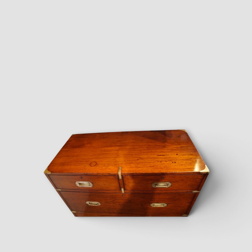 A Victorian teak two-part military campaign chest of drawers featuring flush brass handles, brass corner mounts, and turned feet. View XIII