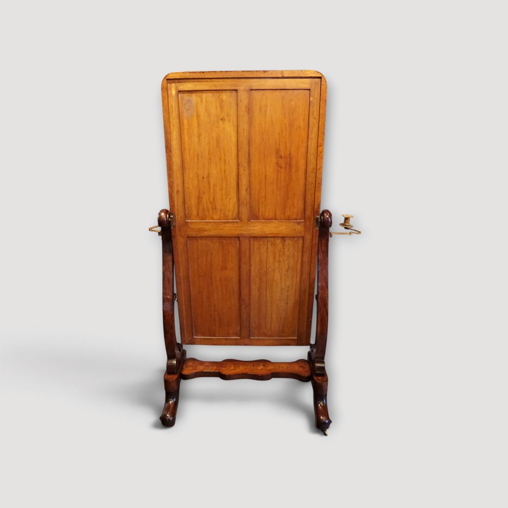 A Victorian mahogany cheval mirror with a rectangular rounded tilting glass frame, dual upright supports, and a curved plinth base set on scroll legs. View X
