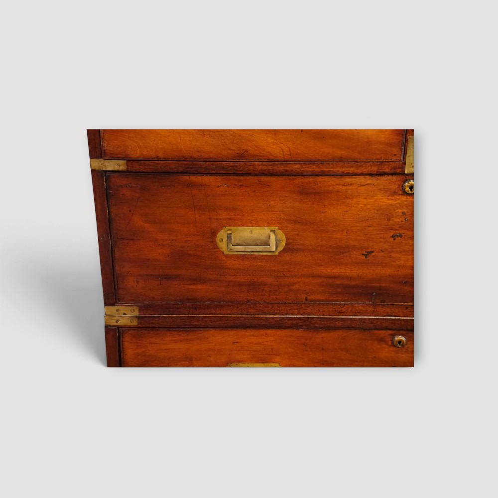 A Victorian mahogany campaign chest featuring two short drawers over three long drawers with flush brass handles, brass corner brackets, and turned feet. View VII