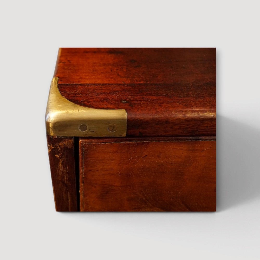 A Victorian mahogany campaign chest featuring two short drawers over three long drawers with flush brass handles, brass corner brackets, and turned feet. View VIII