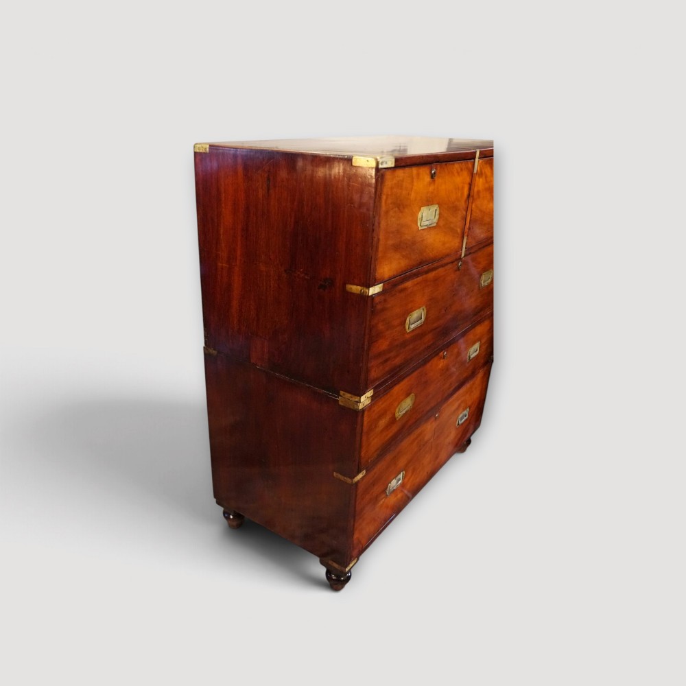 A Victorian mahogany campaign chest featuring two short drawers over three long drawers with flush brass handles, brass corner brackets, and turned feet. View IX