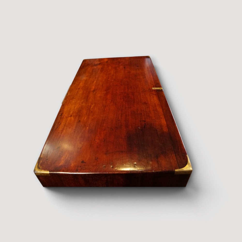 A Victorian mahogany campaign chest featuring two short drawers over three long drawers with flush brass handles, brass corner brackets, and turned feet. View XI