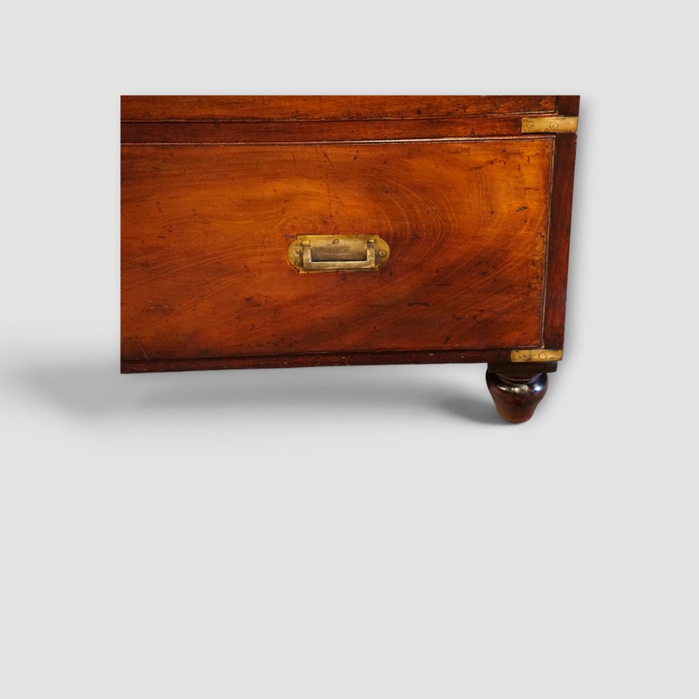 A Victorian mahogany campaign chest featuring two short drawers over three long drawers with flush brass handles, brass corner brackets, and turned feet. View XII