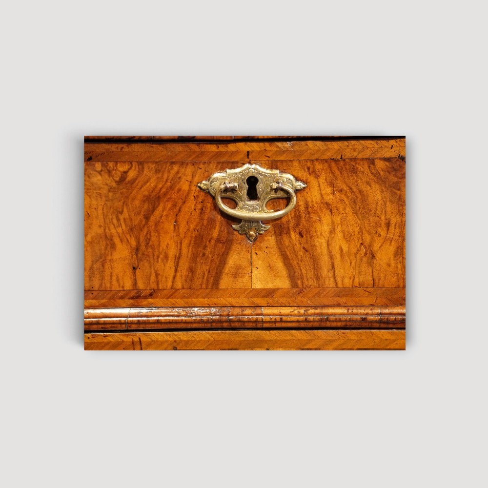 An antique Queen Anne walnut chest-on-chest in two sections featuring a multi-drawer configuration, figured grain patterns, brass drop handles, and bun feet. View VIII