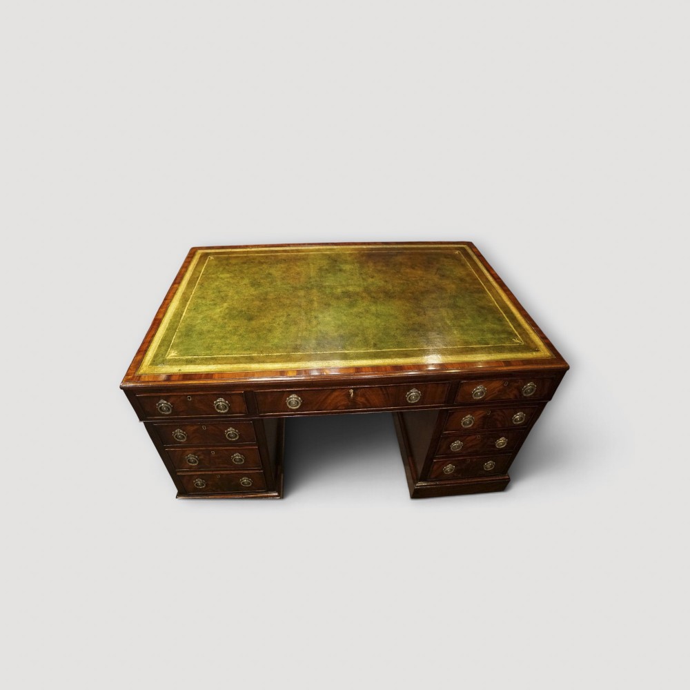 A Victorian mahogany partners desk featuring a green leather writing surface, dual pedestals with drawers, and round brass handles. View V
