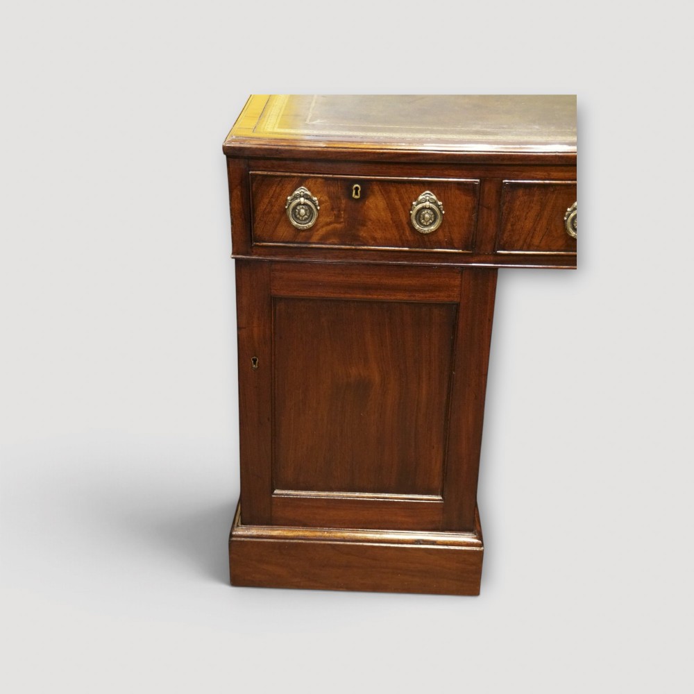 A Victorian mahogany partners desk featuring a green leather writing surface, dual pedestals with drawers, and round brass handles. View VII