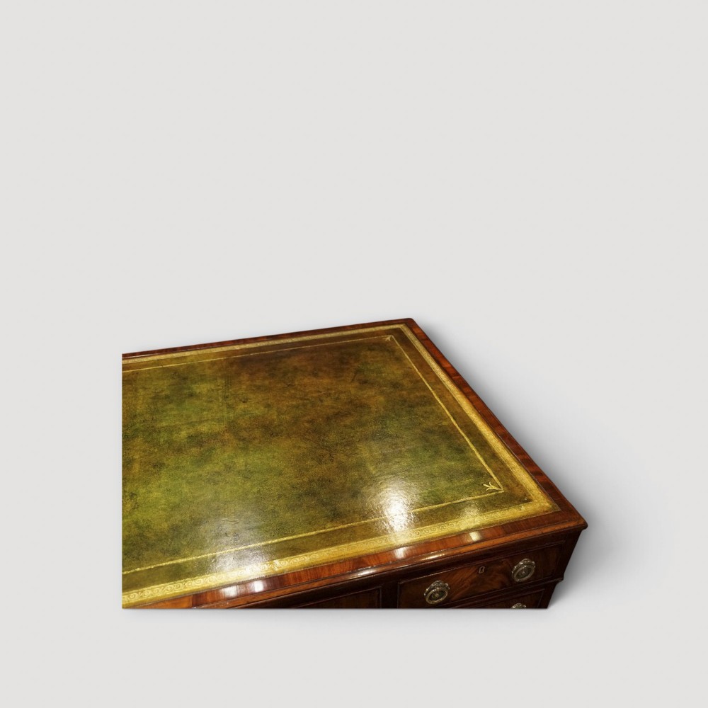 A Victorian mahogany partners desk featuring a green leather writing surface, dual pedestals with drawers, and round brass handles. View X