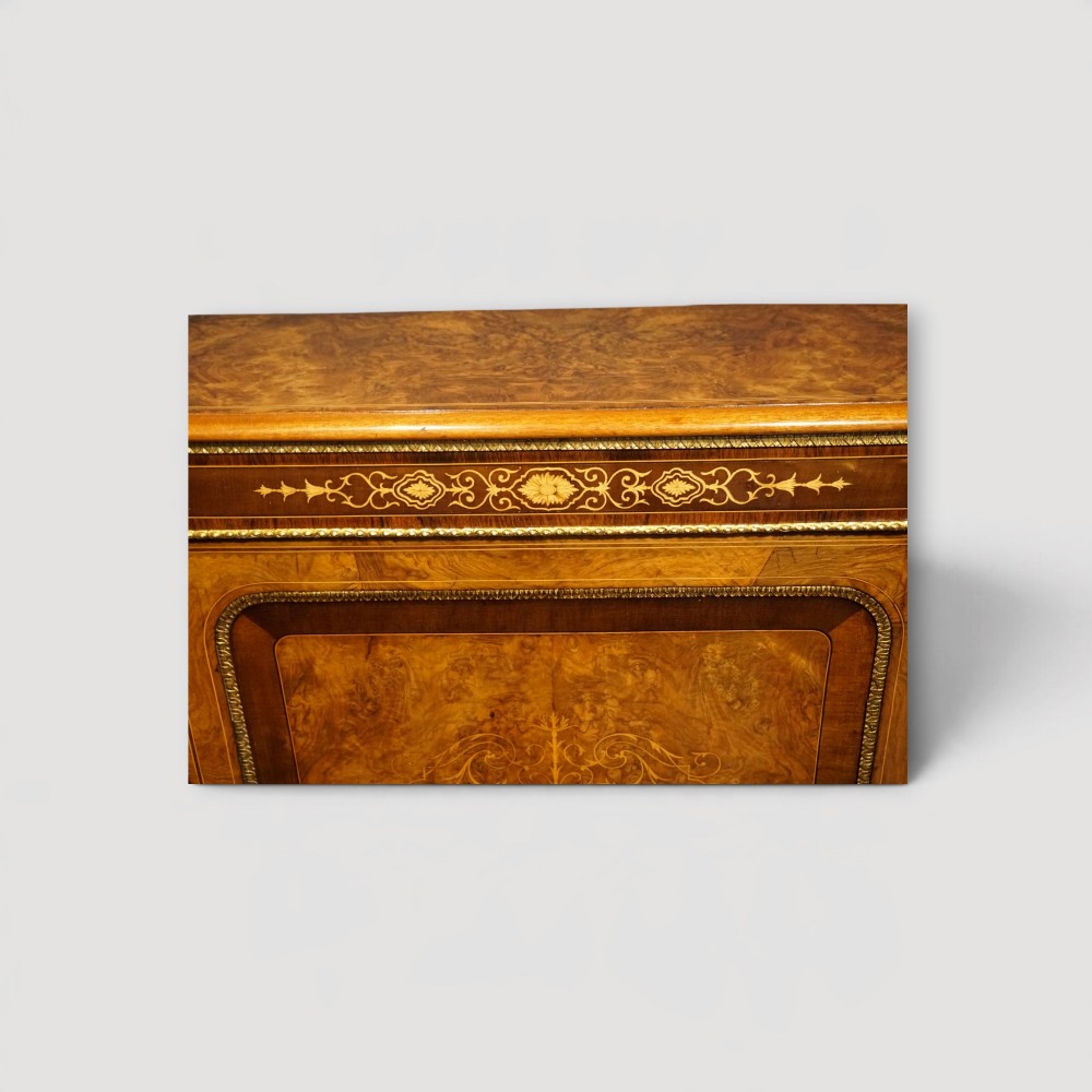A Victorian burr walnut credenza featuring a central marquetry inlaid door flanked by two curved glazed display side cabinets with gilt mounts. View IX