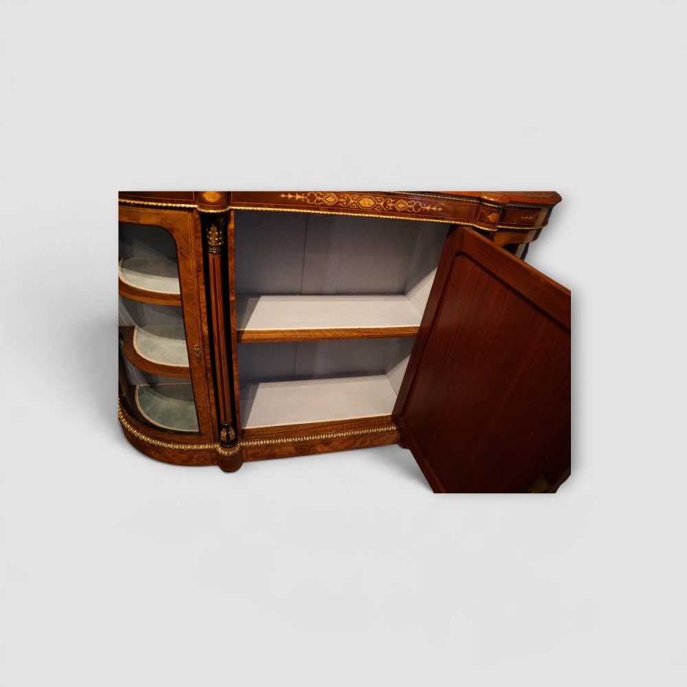 A Victorian burr walnut credenza featuring a central marquetry inlaid door flanked by two curved glazed display side cabinets with gilt mounts. View X
